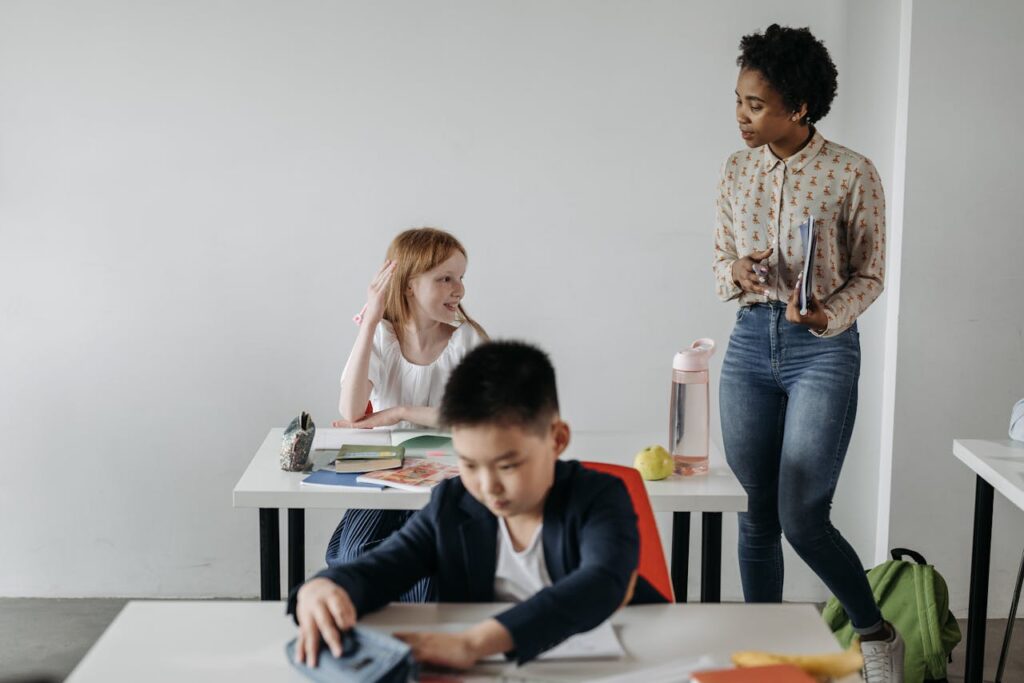 Teacher assisting diverse students in a classroom environment, promoting education and learning.